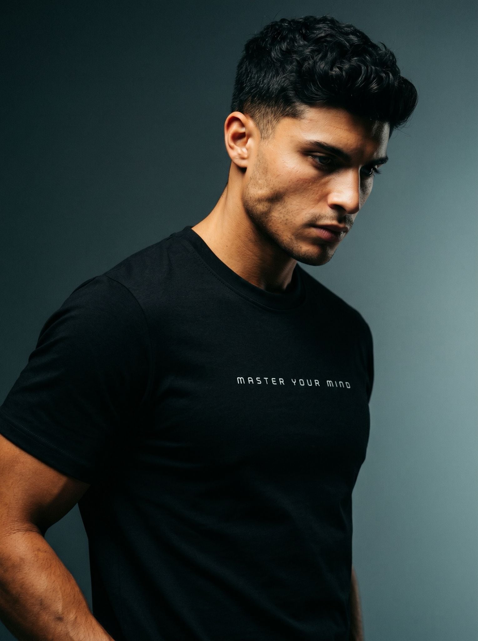 Portrait mi-corps en t-shirt noir Master your mind, lumière latérale