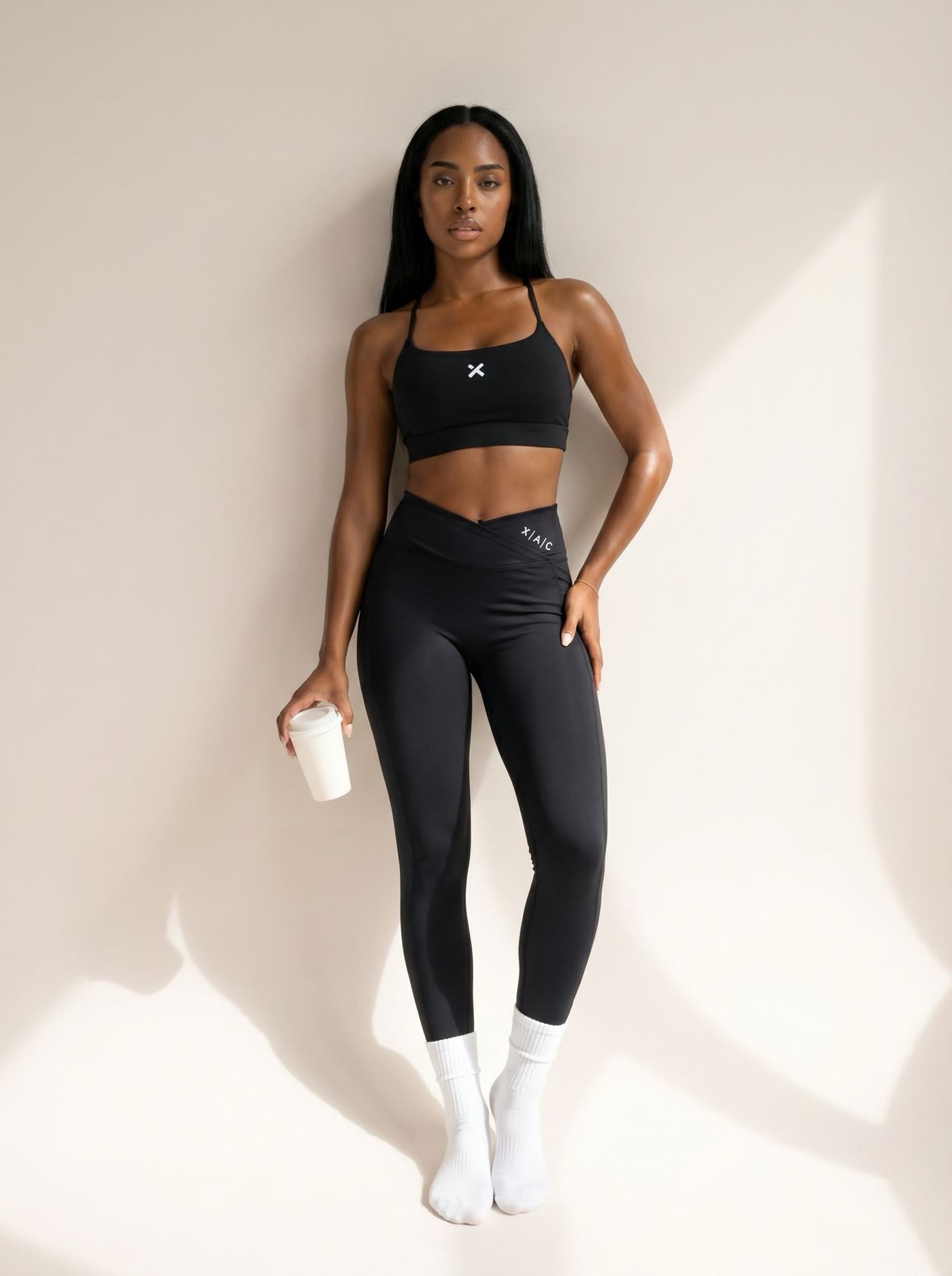 Athlète en brassière noire et leggings Pulse noir, debout en studio